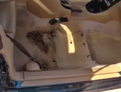 Heavily stained beige car carpet before cleaning