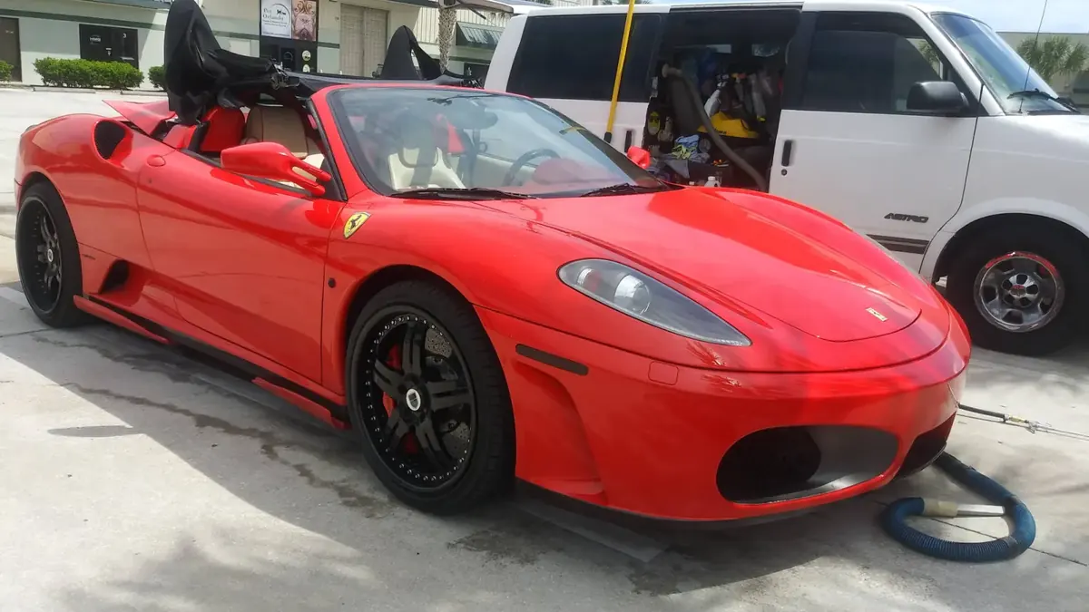 Red Ferrari F430 Spider after a full detail, parked next to the work van