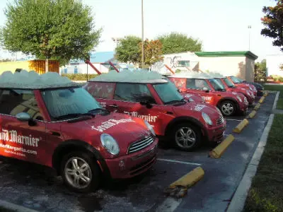Row of branded red MINI Cooper fleet cars in a parking lot