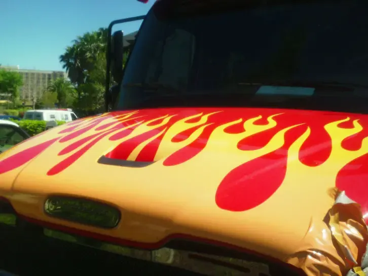 Hood covered in red and yellow flame graphics before removal